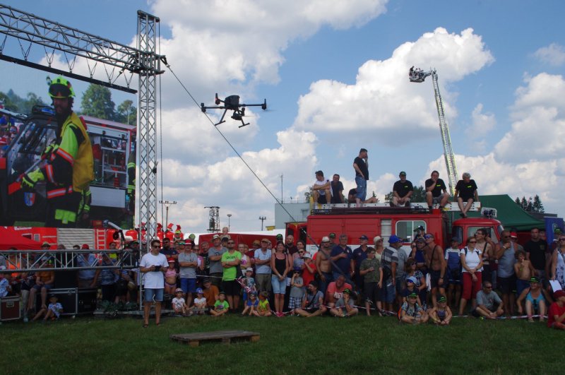 Tisíce přihlížejících na setkání PyroCar sledují start dronů, veškeré dění bylo přenášeno na velkoplošnou obrazovku