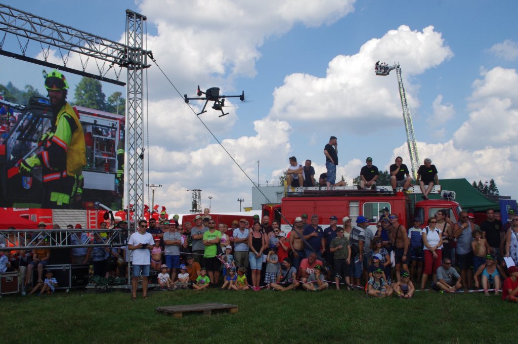 Tisíce přihlížejících na setkání PyroCar sledují start dronů, veškeré dění bylo přenášeno na velkoplošnou obrazovku