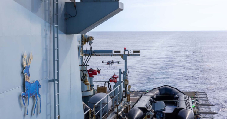 DRON letí vedle boku hlídkové lodi HMS Trent nad mořem